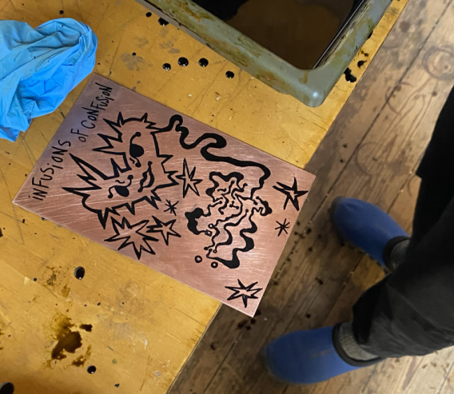 process of etching a printable circuit board. the circuit has an antenna in the shape of a pointy heart and a sentence that says " infusion of confusion"
